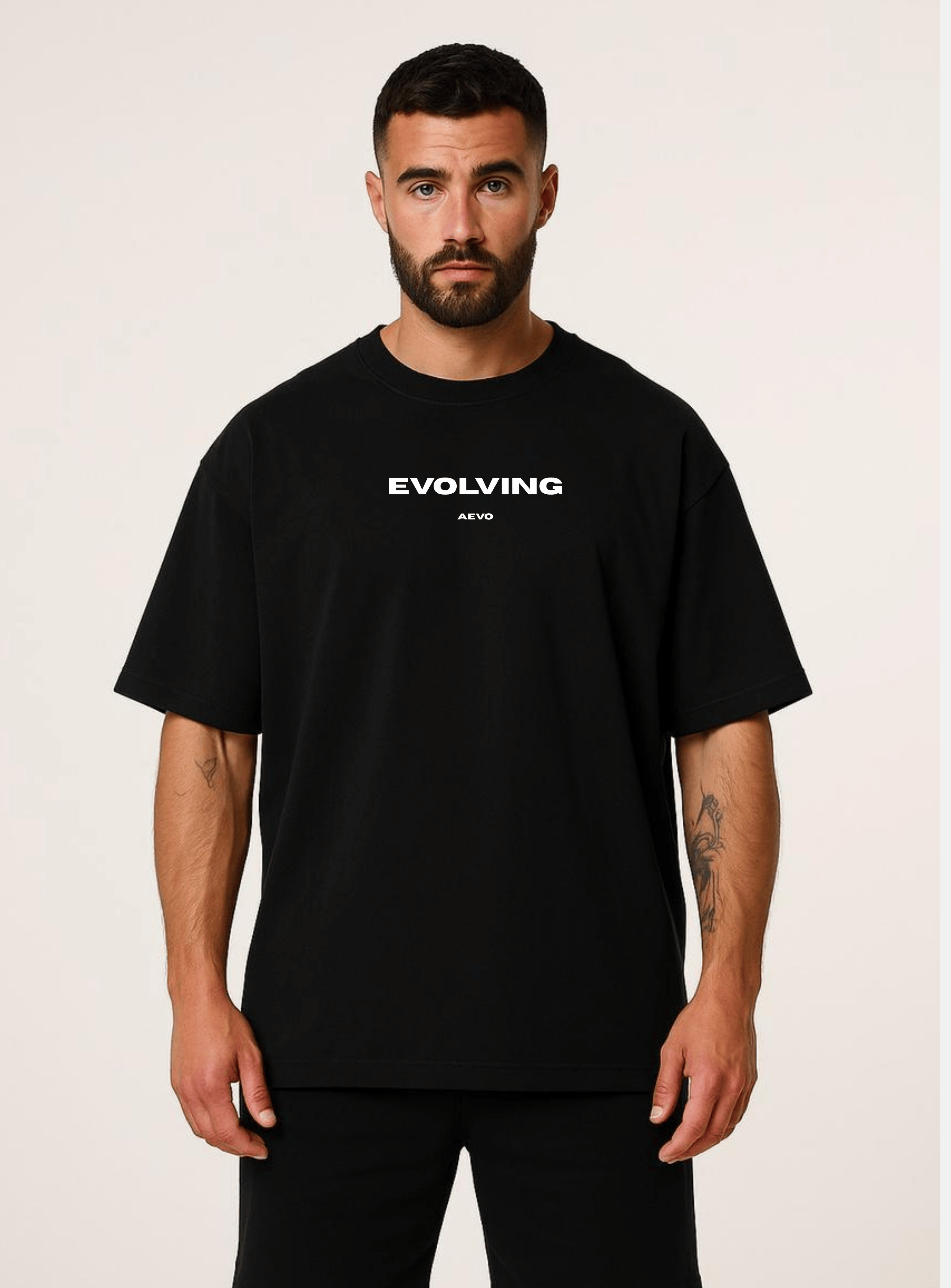 Man wearing a black t-shirt with 'Evolving' text on a plain background