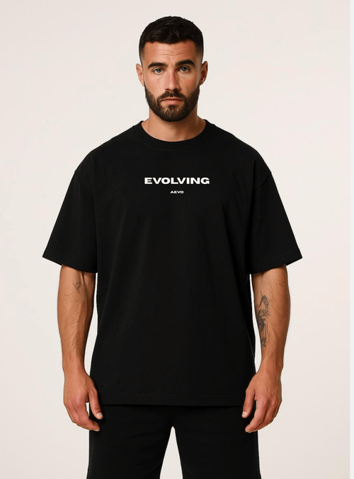 Man wearing a black t-shirt with 'Evolving' text on a plain background